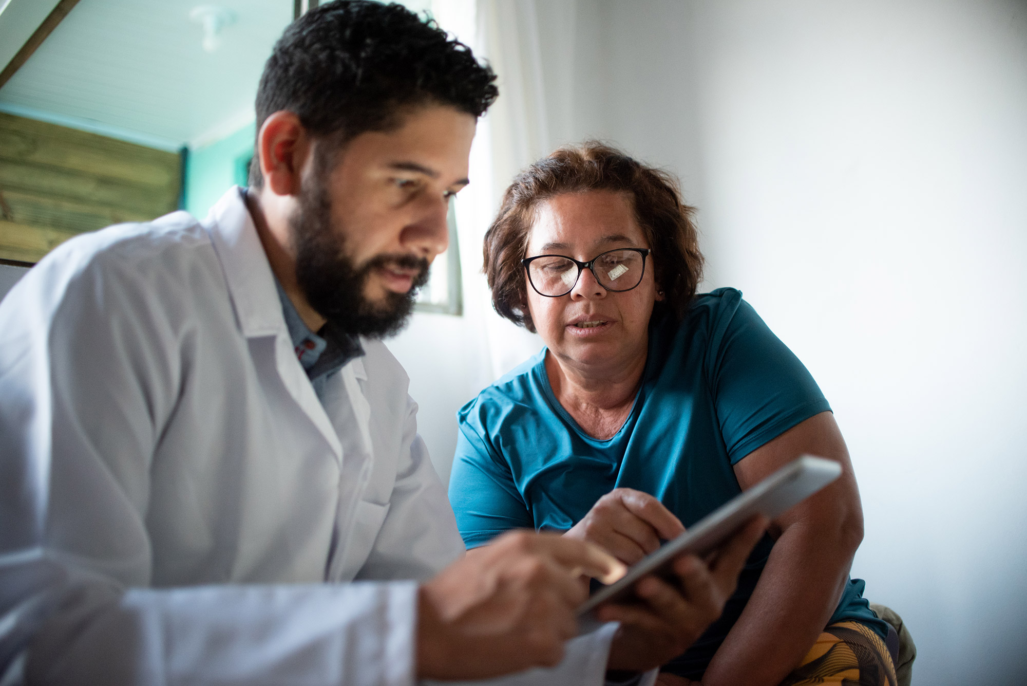 a-doctor-and-woman-looking-at-a-tablet a doctor and woman patient looking at a tablet