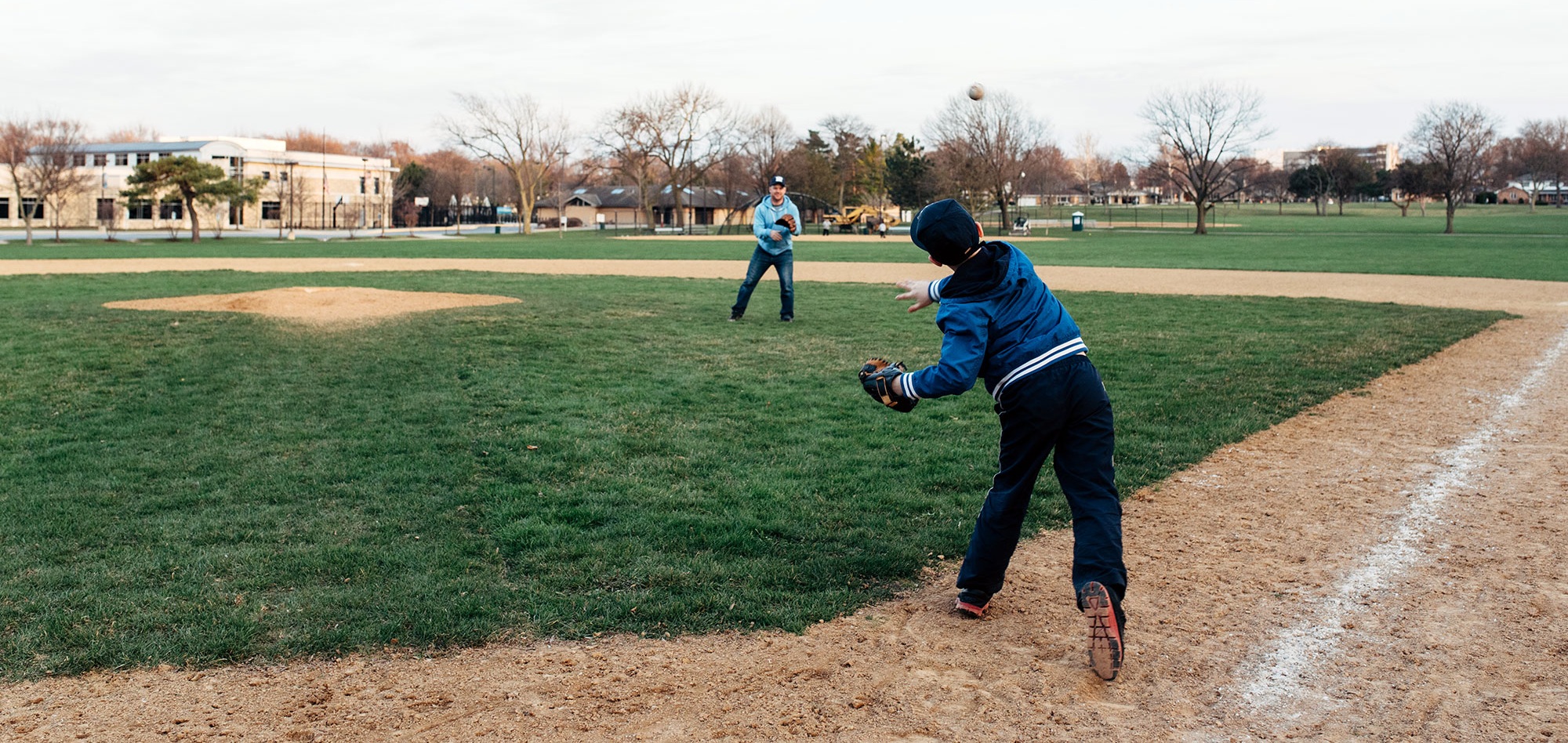 man and boy playing baseball outdoors
