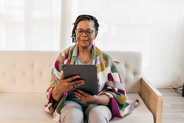 woman sitting on couch reading tablet