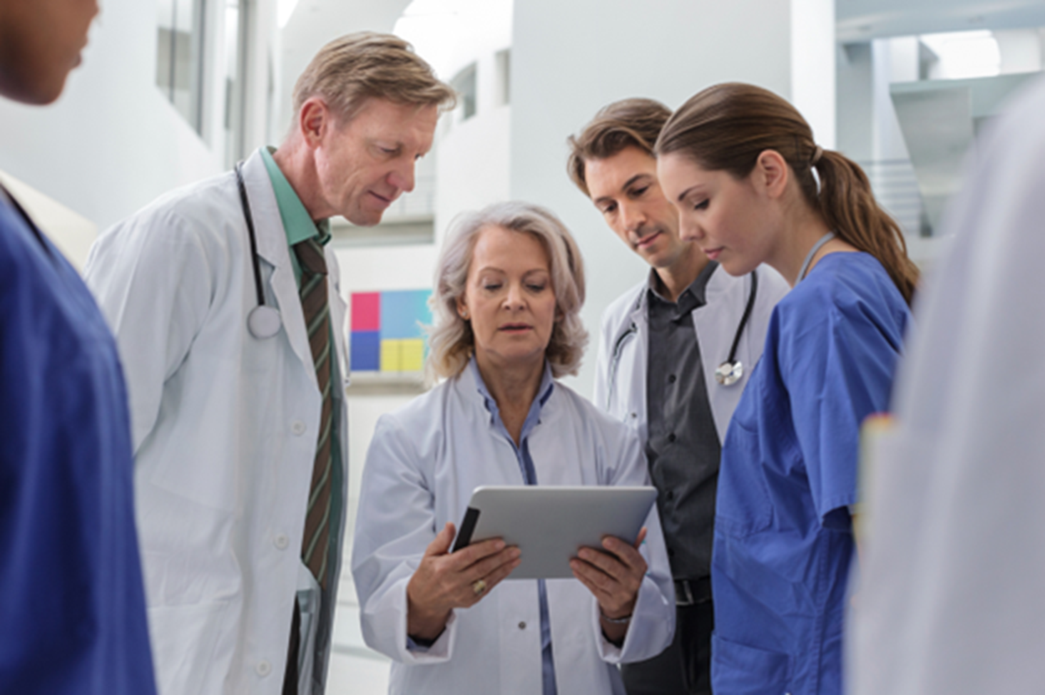 doctors-and-nurses-hudled-around-tablet doctors and nurses huddled around a tablet
