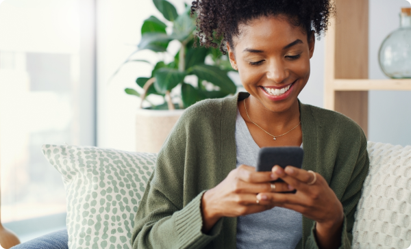 a woman sitting on a couch looking at a phone